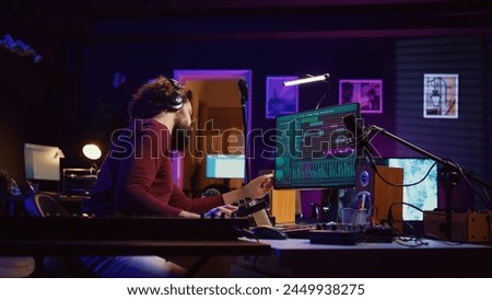 Soundtrack producer adjusts and mixes additional sounds to audio files while changing noise settings, using an USB stick. Artist plays piano and uses a mixing console and audio plug ins. Camera B.
