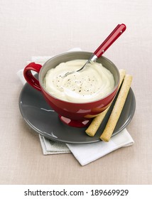 Soup Cauliflower Puree With Bread Sticks In A Red Bowl