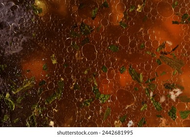 Soup. Honest clear beef broth made from quality ingredients.Detail of the luxurious broth. The surface of the soup with greasy mesh. Broth of meat and bones and vegetables.A close-up view of the soup.