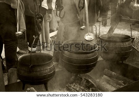 Soup and hot wine preparation at traditional Christmas Medieval fair in Provins (France). Sepia.