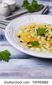 Soup with millet and vegetables on a wooden background. Selective focus.