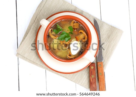 Soup with mushrooms and potatoes in a ceramic bowl
