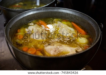 Soup with vegetables is cooked on the stove in the kitchen