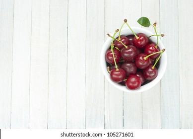 Sour Cherries In China Dish On White Wooden Table, Directly Above