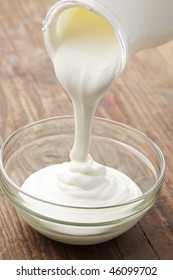 Sour Cream Pouring Into A Glass Bowl