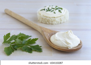 Sour Cream In Wooden Spoon On Wooden Background.