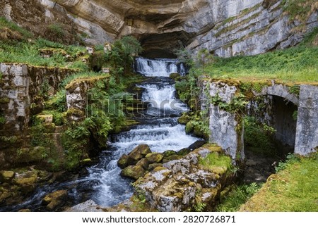 Source of the Loue, featuring a waterfall and cave in a Jura Nouailles Gorge in Ouhans, Bourgogne-Franche-Comté, France.