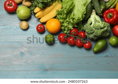 Source of protein for vegetarians. Different fresh vegetables, fruits and cereals on light blue wooden table, top view. Space for text