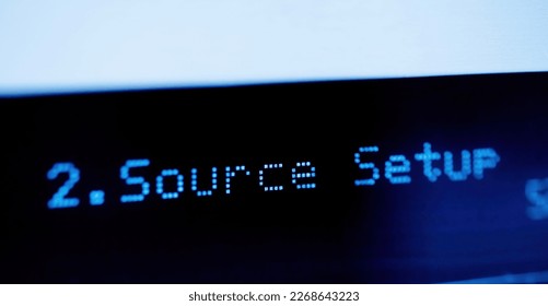 Source setup text on the LCD display aluminum facade figh-end stereo audio hi-fi receiver - close-up tilt-shift lens used