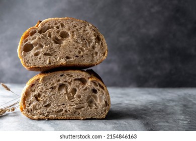 Sourdough Artisan Homemade Bread Sliced In Halfs, Dark Background, Copy Space