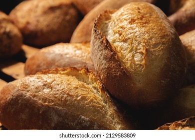 Sourdough bread close-up. Freshly baked round bread with golden crust on bakery shelves. The context of a German bakery with a rustic assortment of bread.