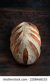 Sourdough bread. Freshly baked organic wheat bread on dark background. Top view. - Shutterstock ID 2208468153