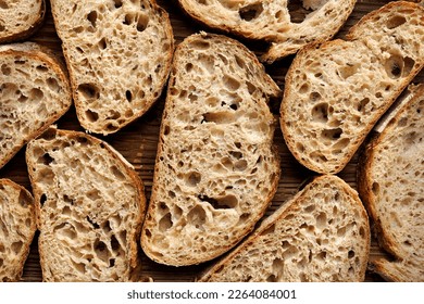 Sourdough bread slices on wooden background, top view. Bread background