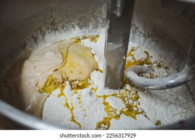 Sourdough, flour, yeast and olive oil being mixed in a dough mixer machine in a bakery - Powered by Shutterstock