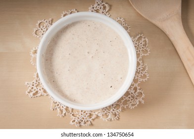 Sourdough in a white bowl on a antique cream doily