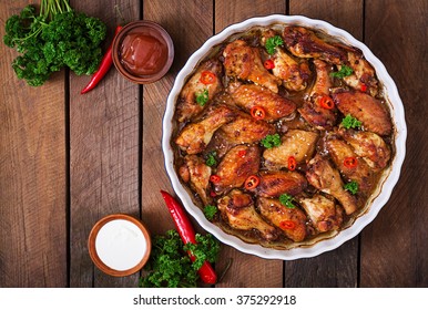 Sour-sweet baked chicken wings and sauce. Top view - Shutterstock ID 375292918