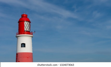 Souter Lighthouse, at Marsden Bay, South Shields, Tyne and Wear, England UK. With blue sky background and clouds.  Image shows red top of lighthouse with light lenses. - Shutterstock ID 1324073063