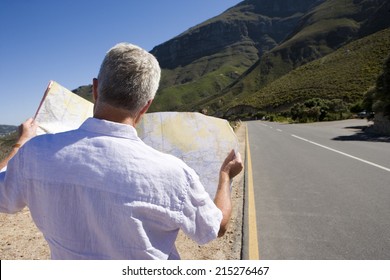 South Africa, Cape Town, Mature Man Looking At Map By Road, Rear View