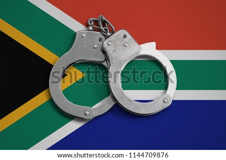South Africa flag  and police handcuffs. The concept of observance of the law in the country and protection from crime