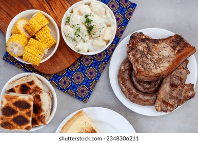 South African Braai Day or Heritage Day. Celebrating traditional braai food.
Meat and sides with traditional Shwe-Shwe cloth.

 - Shutterstock ID 2348306211