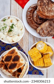 South African Braai Day or Heritage Day. Celebrating traditional braai food.
Meat and sides with traditional Shwe-Shwe cloth.

 - Shutterstock ID 2348306213