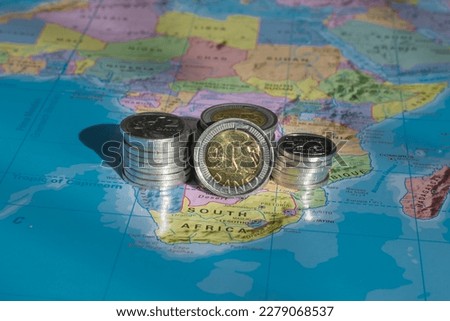 South African Coins in a Pile, Map background, showing one, two and five Rand, Close Up