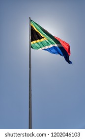 South African Flag Flapping In The Wind Lighted By The Sun At Its Back