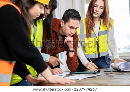 South american engineer supervisor at construction site with his multiethnic work team setting guidelines in building site office - Teamwork concept