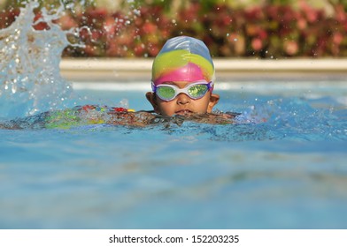 South Asian Indian boy in the swimming pool with goggles in Arab resort - Powered by Shutterstock