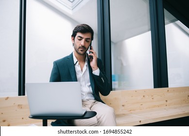 South Asian Male Entrepreneur Have Multitasking Job Via Modern Technology Checking Received Business Email On Digital Laptop, Man In Formal Apparel Reading Financial News While Phoning On Mobile