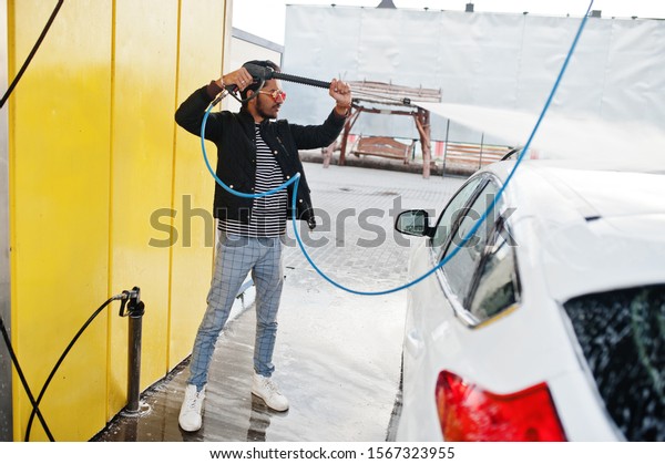 South asian man or indian male washing his white
transportation on car
wash.