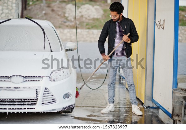 South asian man or indian male washing his white
transportation on car
wash.