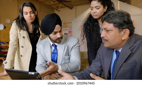 The South Asian Office Colleagues Having Disagreement With Their Sikh Turbaned Boss In Front Of A Laptop Monitor