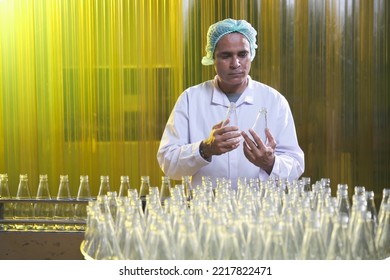 South Asian Senior Male Factory Worker Or Expert Quality Staff Is Checking Bottles Line For Beverage