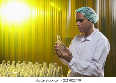 South Asian Senior Male Factory Worker Or Expert Quality Staff Is Checking Bottles Line For Beverage