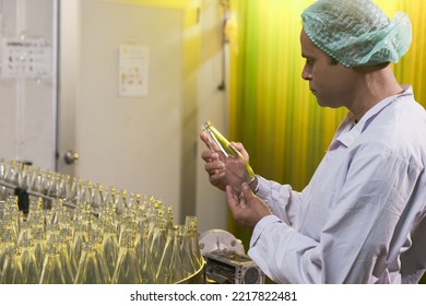 South Asian Senior Male Factory Worker Or Expert Quality Staff Is Checking Bottles Line For Beverage