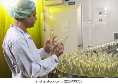 South Asian Senior Male Factory Worker Or Expert Quality Staff Is Checking Bottles Line For Beverage