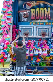 South Bend Indiana USA July 4 2021; A Young Man Tosses A Basketball Into A Net As He Plays A Carnival Game At A County Fair