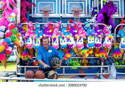 South Bend Indiana USA July 4 2021; Laughing Carnival Worker Enjoys His Job As He Waits For Players At His Fair Booth