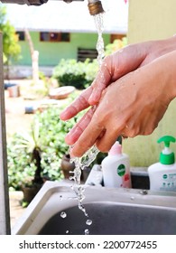 
South Borneo, Indonesia - September 2022: A Woman Washes Her Hands In The Sink On A Blurred Background