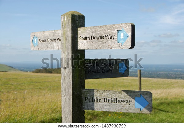 South Downs National Park, Sussex, England, UK.\
A signpost shows the route of the South Downs Way with views over\
the Sussex Weald. The South Downs Way is a national trail popular\
with walkers.