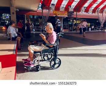 South East Asia / Singapore - October 26, 2019 : Asian Chinese Elderly Woman In Wheelchair Using Mobile Tablet