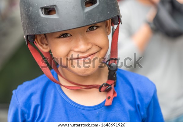 South East Asia /\
Singapore - September 14, 2019 : Malay muslim boy smiling happily\
wearing safety helmet.