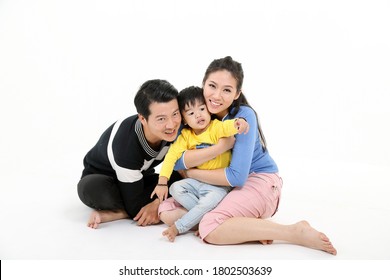 South East Asian Chinese Couple Husband Wife Son Child Play Sit On Floor Look At Camera White Background Love