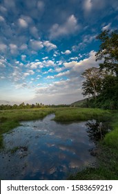 South East Asian Countryside With A Blue Sky And The Clouds Reflecting In The Water Sourounded By Greenery 