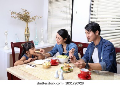 South East Asian Yong Family Daughter Child Parent Father Mother At Dining Table Eating Food Lunch Dinner