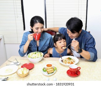 South East Asian Yong Family Daughter Child Parent Father Mother At Dining Table Eating Food Lunch