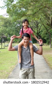 South East Asian Young Chinese Father Daughter Parent Child Playing Activity Outdoor Park Riding On Fathers Shoulders