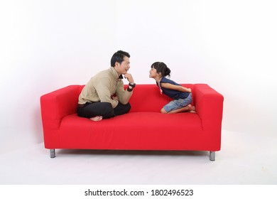 South East Asian Young Father Daughter Parent Girl Child On Red Sofa Playing Fun Happy Smile On White Background