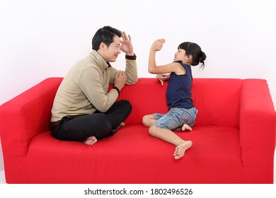 South East Asian Young Father Daughter Parent Girl Child On Red Sofa Playing Fun Happy Smile On White Background
